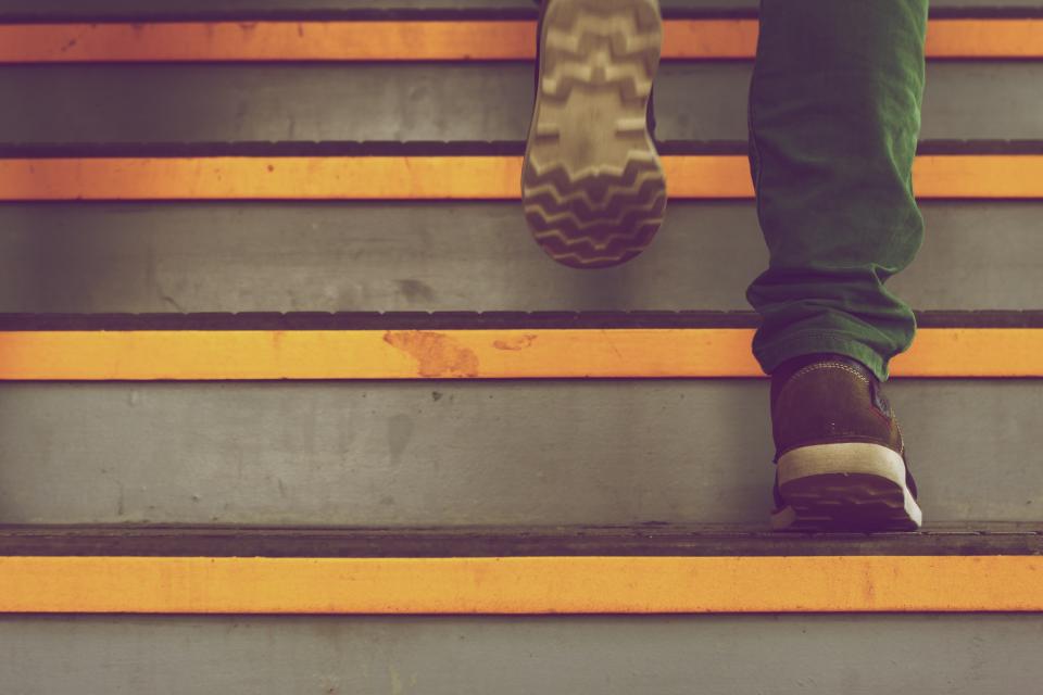 Close-up of feet climbing a staircase