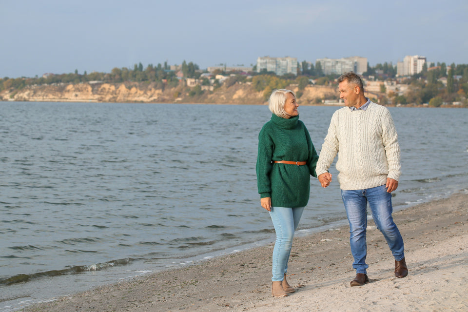Older couple walking hand in hand along the beach