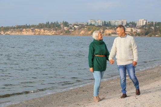 Older couple walking hand in hand along the beach
