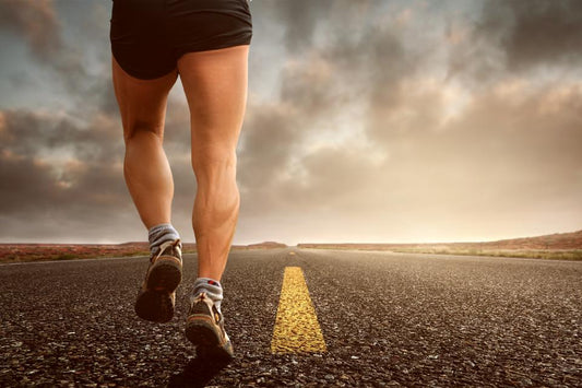 Legs of a person running on an open road