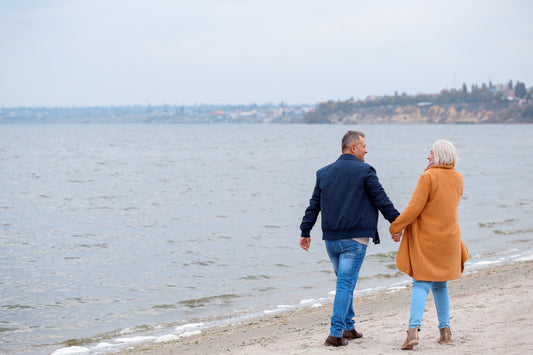 Older couple walking hand in hand along the beach