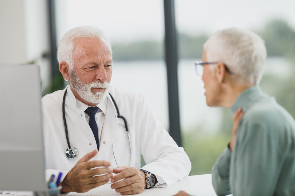 Doctor listening to an older patient during a consultation