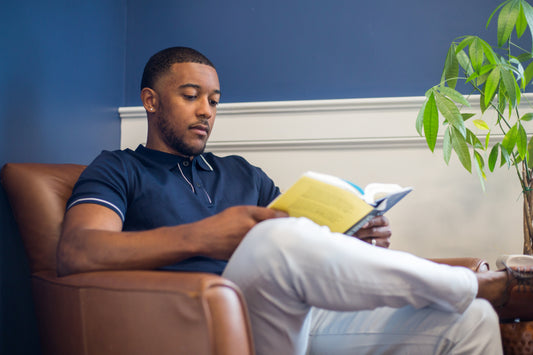 Man reading a book in an armchair