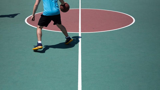 Basketball player dribbling on an outdoor court