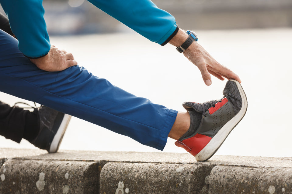 Person stretching the back of the leg and calf outdoors