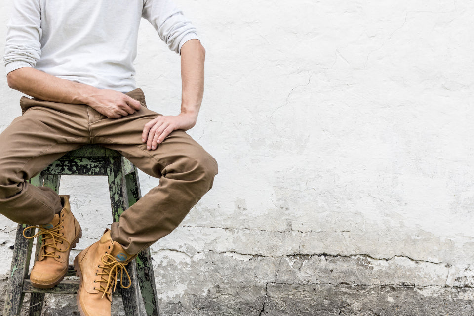 Man sitting on a stool with his knees bent