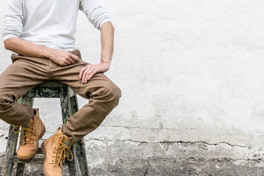 Man sitting on a stool with his knees bent