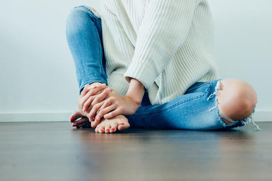Woman sitting on the floor with her knees bent
